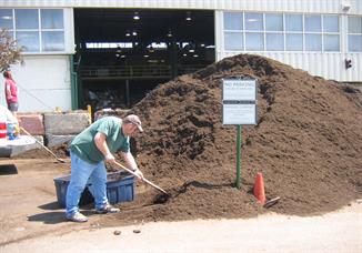 Person shoveling compost pile