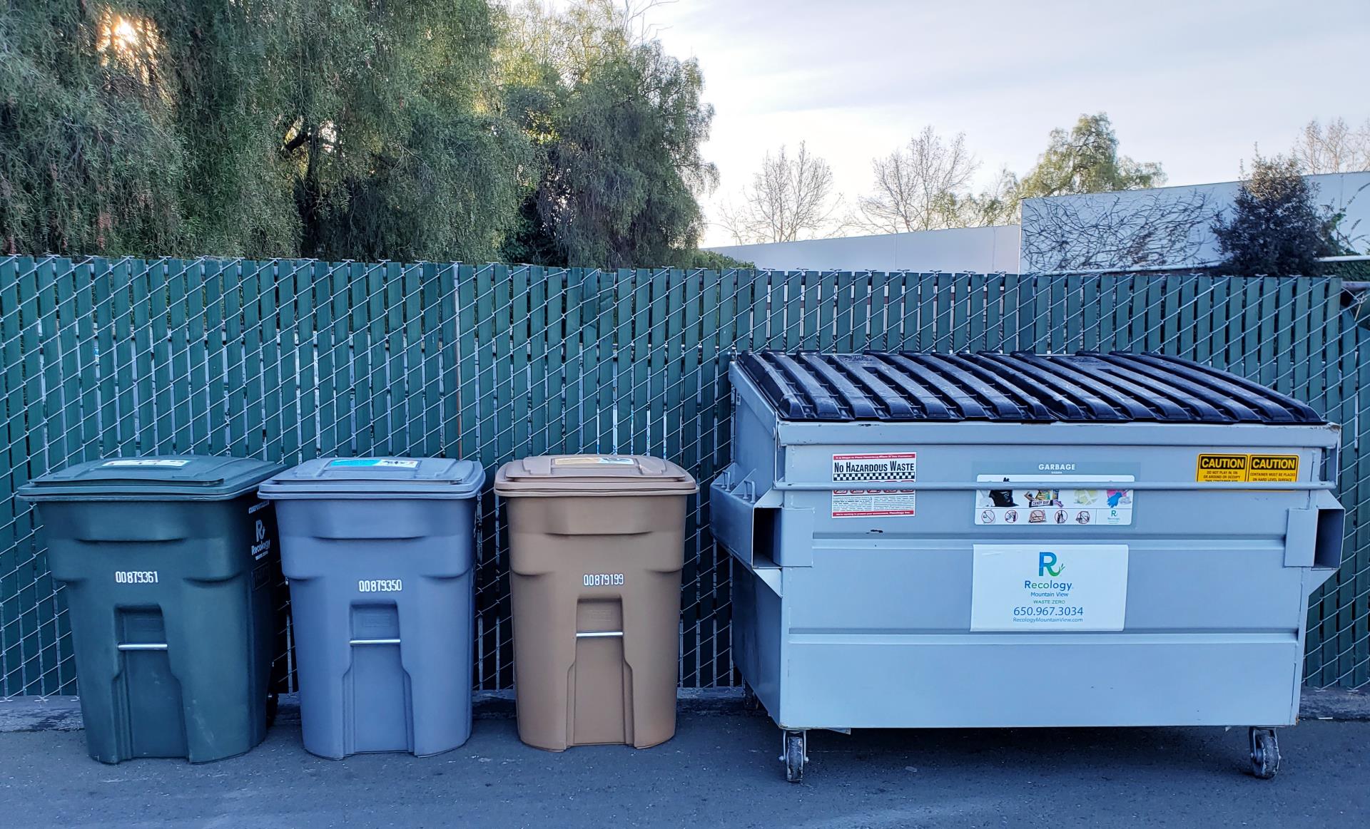 Garbage bins next to dumpster