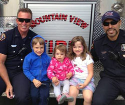 Firefighters posing with children