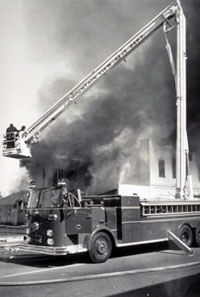 Black and white historic photo of fire truck and ladder
