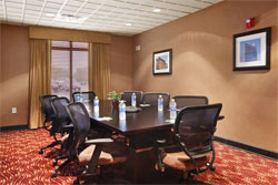An empty meeting room with water bottles at each seat.