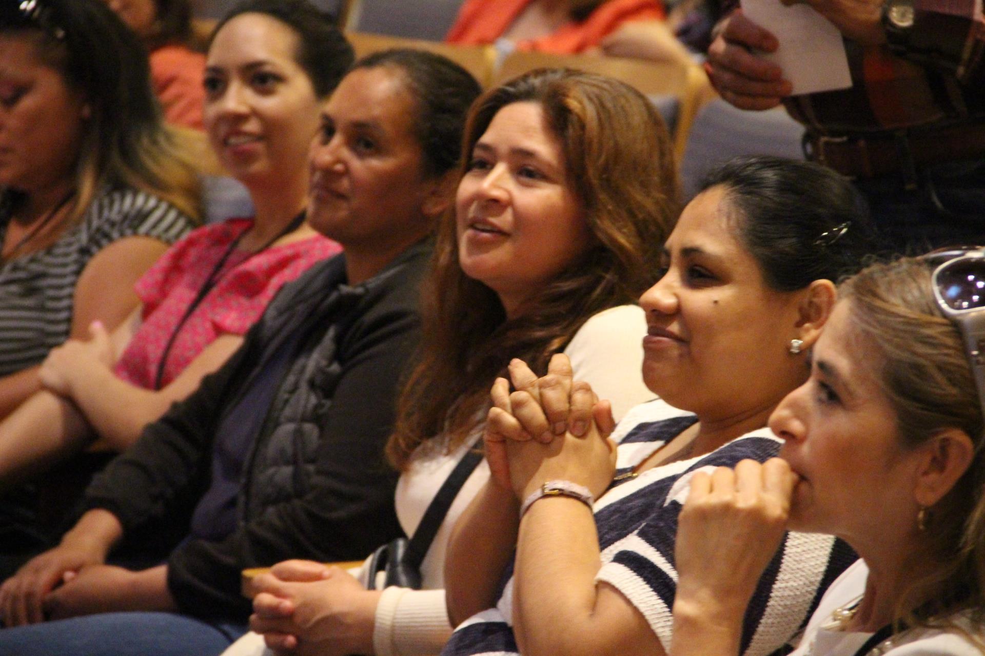 Latina women sitting in an audience